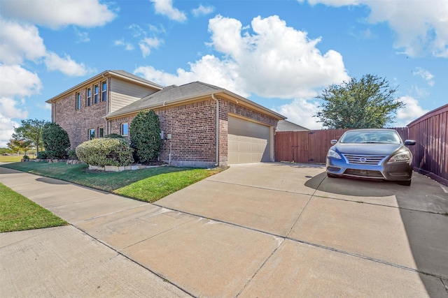 view of front facade featuring a front lawn, fence, brick siding, an attached garage, and driveway