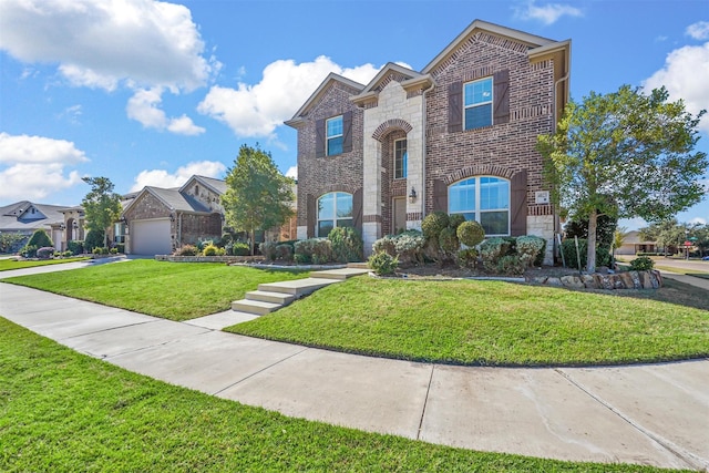 traditional-style home featuring brick siding, stone siding, a front yard, and concrete driveway