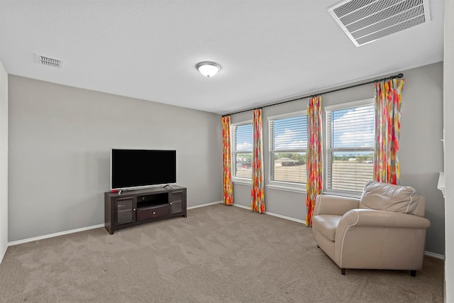 living area with visible vents, carpet flooring, and baseboards