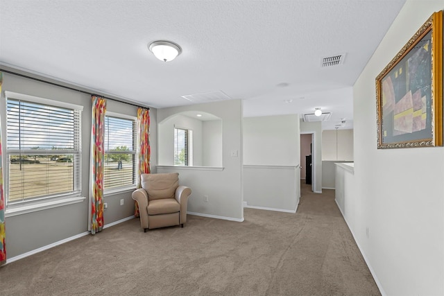unfurnished room featuring carpet floors, a textured ceiling, visible vents, and baseboards
