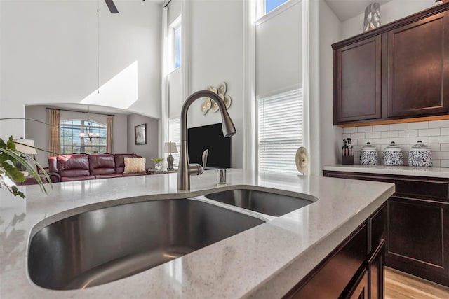 kitchen with light stone countertops, open floor plan, plenty of natural light, and a sink