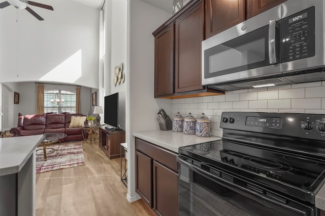 kitchen featuring dark brown cabinetry, tasteful backsplash, black range with electric stovetop, light hardwood / wood-style floors, and ceiling fan