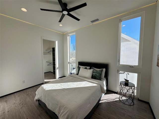 bedroom featuring multiple windows, wood-type flooring, and ceiling fan