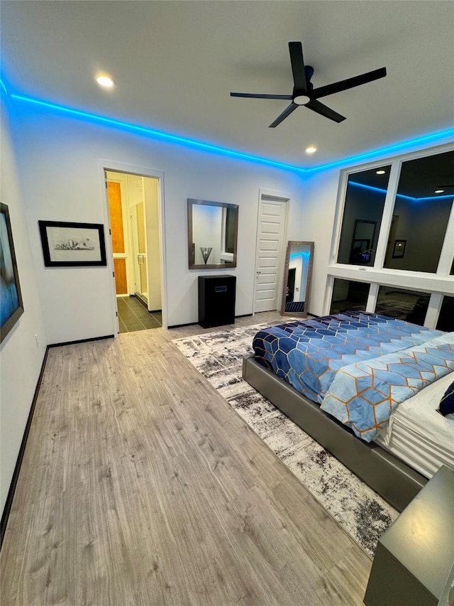 bedroom with ceiling fan, wood-type flooring, and ensuite bath