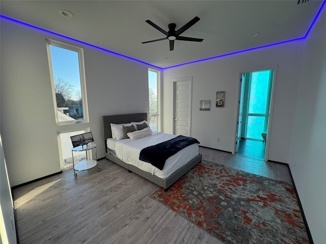 bedroom with ceiling fan, access to exterior, and light hardwood / wood-style flooring