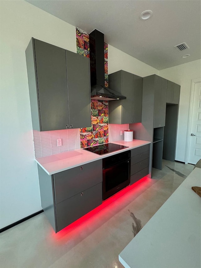 kitchen with black electric cooktop, wall chimney exhaust hood, wall oven, and decorative backsplash