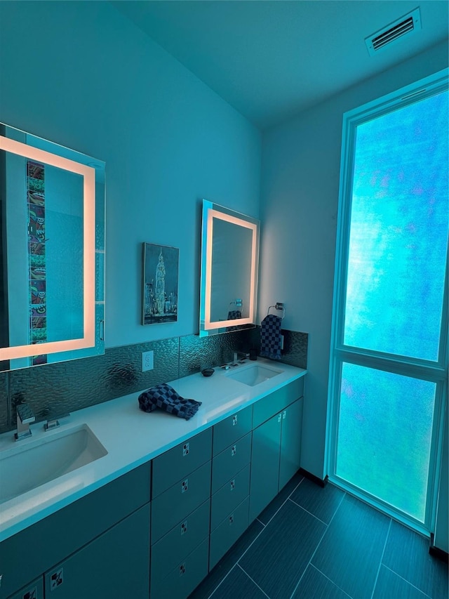 bathroom featuring decorative backsplash, tile patterned floors, and vanity