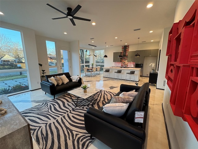 living room featuring ceiling fan and a wealth of natural light