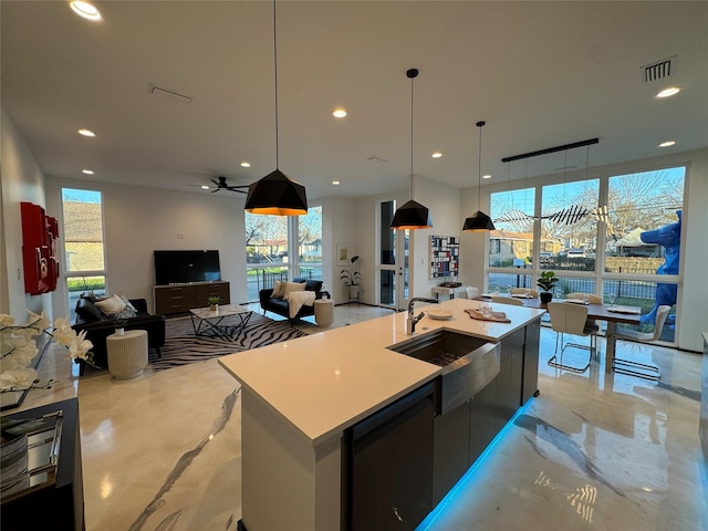 kitchen with plenty of natural light, a large island, sink, and decorative light fixtures