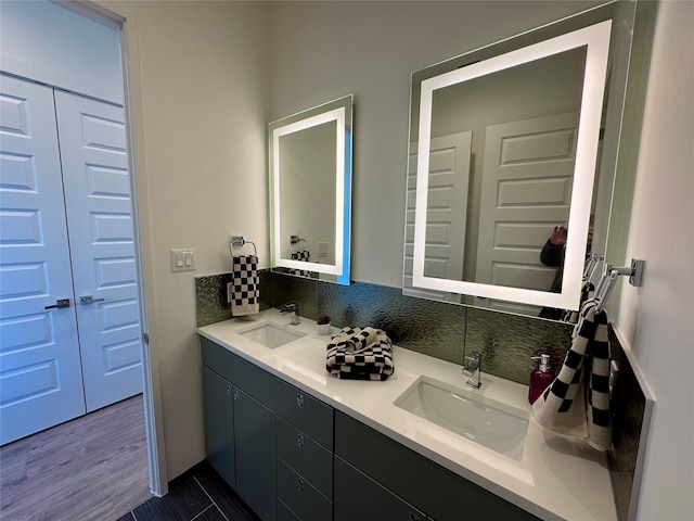 bathroom featuring hardwood / wood-style flooring, vanity, and decorative backsplash