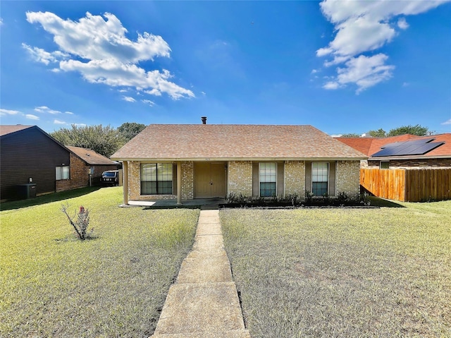 ranch-style home with cooling unit and a front lawn