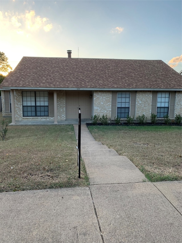 ranch-style house featuring a lawn