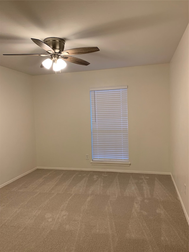 carpeted spare room with ceiling fan