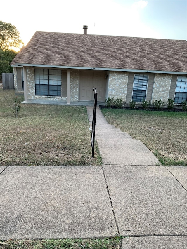 ranch-style home featuring a garage and a front lawn