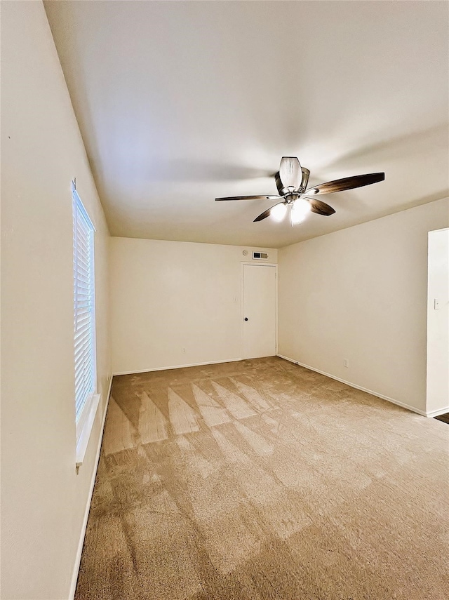 carpeted spare room with ceiling fan