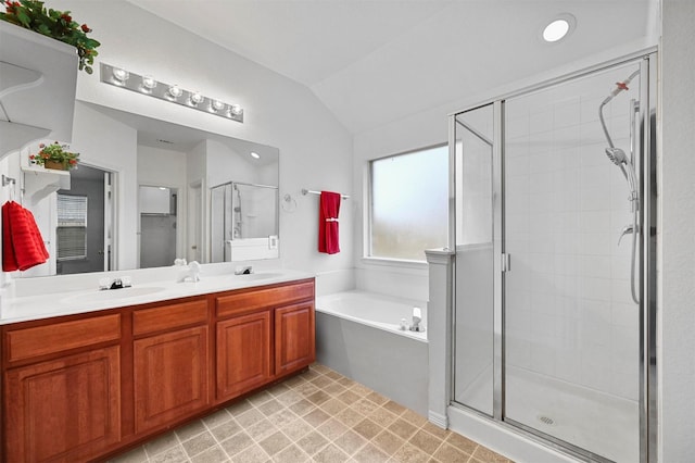 bathroom featuring vaulted ceiling, independent shower and bath, and vanity