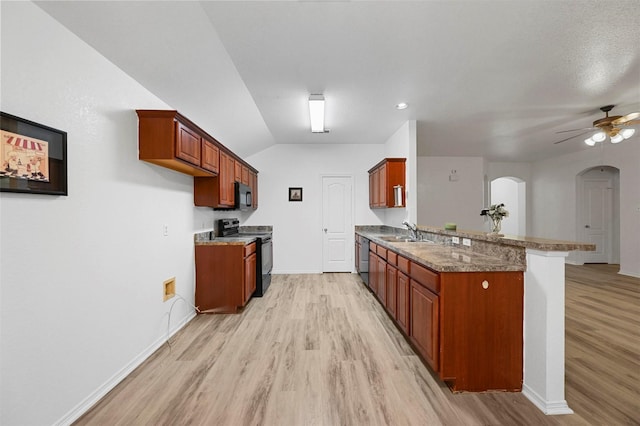 kitchen with ceiling fan, black appliances, kitchen peninsula, light hardwood / wood-style flooring, and dark stone counters