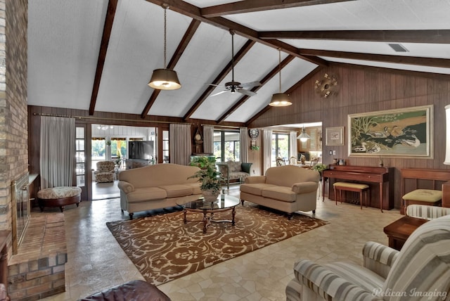 living room with beamed ceiling, a wealth of natural light, wood walls, and ceiling fan