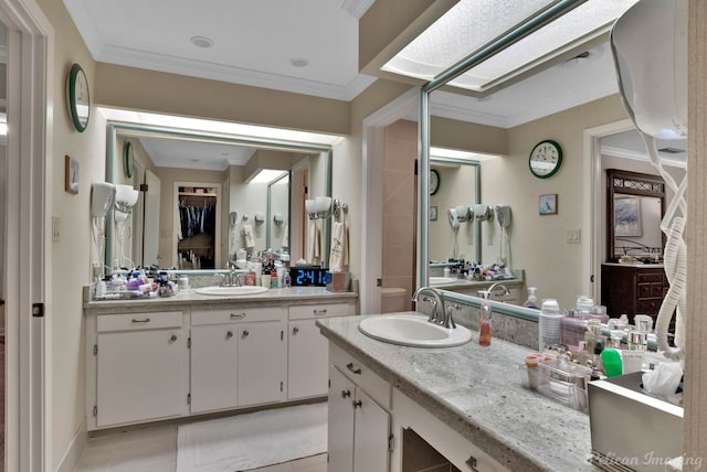 bathroom featuring tile patterned floors, crown molding, and vanity