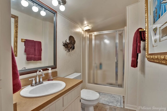 bathroom with toilet, an enclosed shower, and vanity