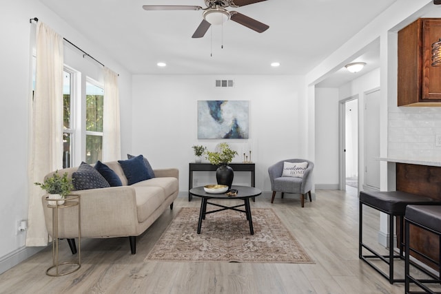 living room with ceiling fan and light hardwood / wood-style flooring