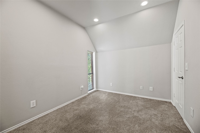 empty room featuring lofted ceiling and dark carpet