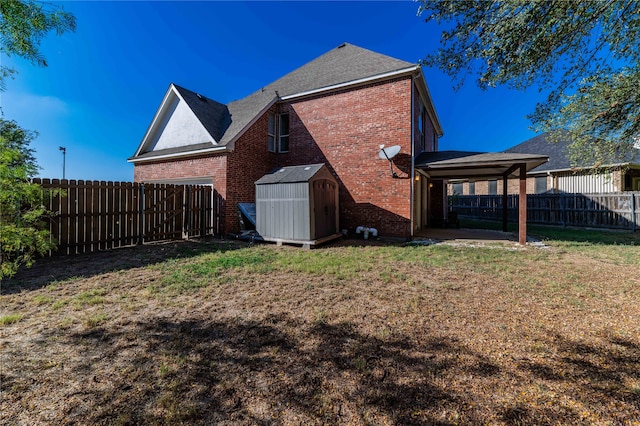 back of house featuring a storage shed and a lawn