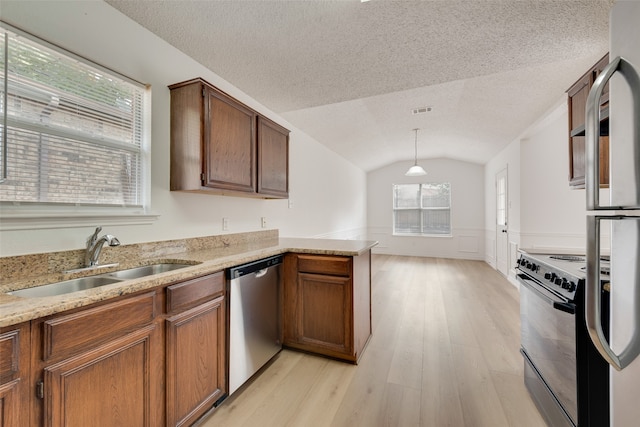 kitchen with appliances with stainless steel finishes, sink, kitchen peninsula, lofted ceiling, and pendant lighting