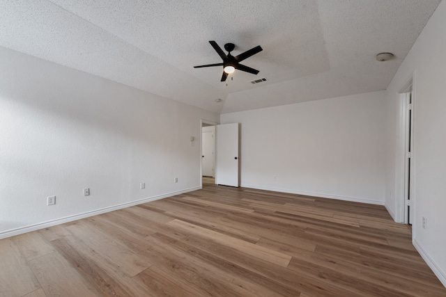 unfurnished room featuring hardwood / wood-style floors, a textured ceiling, vaulted ceiling, and ceiling fan