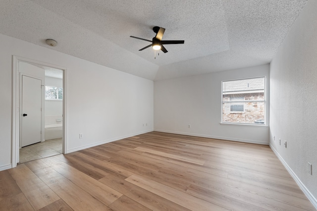 unfurnished room featuring a textured ceiling, light wood-type flooring, and ceiling fan