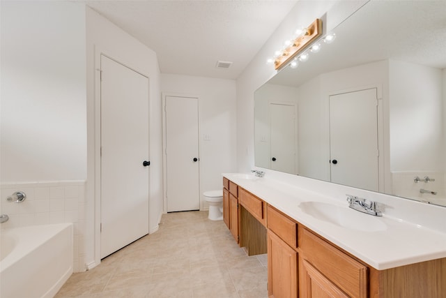 bathroom with a bathtub, a textured ceiling, toilet, vanity, and tile patterned floors