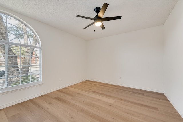 empty room featuring light hardwood / wood-style floors, a wealth of natural light, and ceiling fan