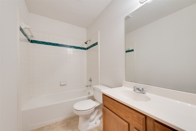 full bathroom featuring tiled shower / bath, a textured ceiling, toilet, vanity, and tile patterned flooring