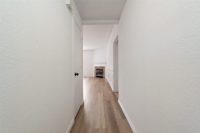 hallway featuring a textured ceiling and light hardwood / wood-style floors