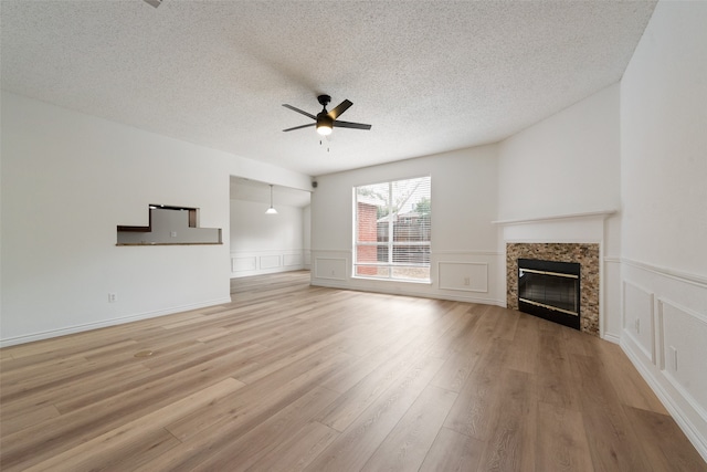 unfurnished living room featuring a textured ceiling, light wood-type flooring, and ceiling fan