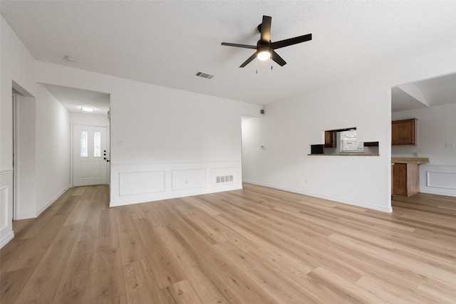 unfurnished living room featuring light hardwood / wood-style floors, a textured ceiling, and ceiling fan