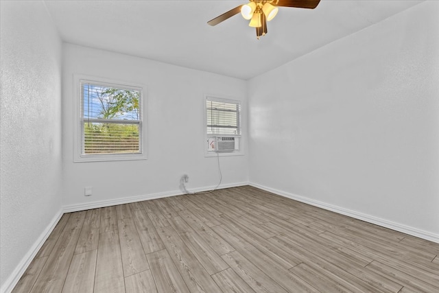 spare room featuring light hardwood / wood-style flooring, cooling unit, and ceiling fan