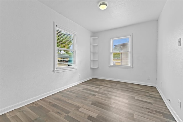 unfurnished room with hardwood / wood-style floors