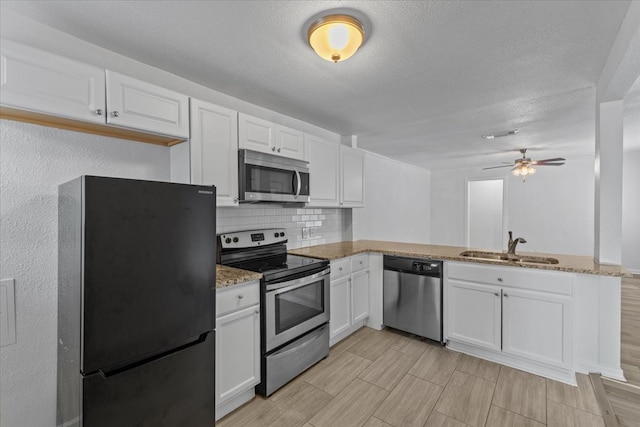 kitchen with sink, backsplash, kitchen peninsula, white cabinetry, and stainless steel appliances