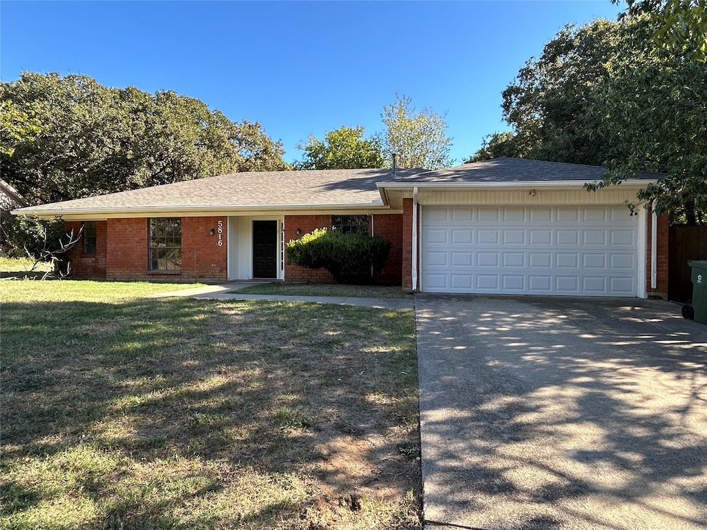 single story home with a front yard and a garage