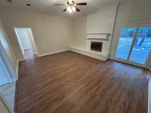 unfurnished living room with a fireplace, dark hardwood / wood-style floors, and ceiling fan