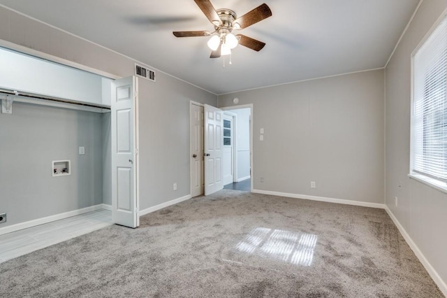 unfurnished bedroom featuring ceiling fan, a closet, and light colored carpet