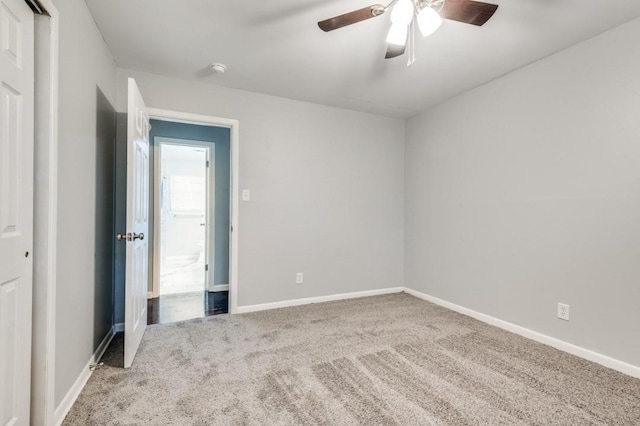 carpeted spare room with ceiling fan