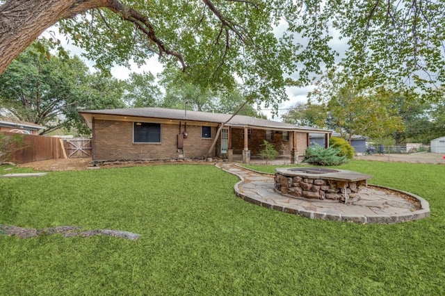 back of property featuring a lawn and an outdoor fire pit