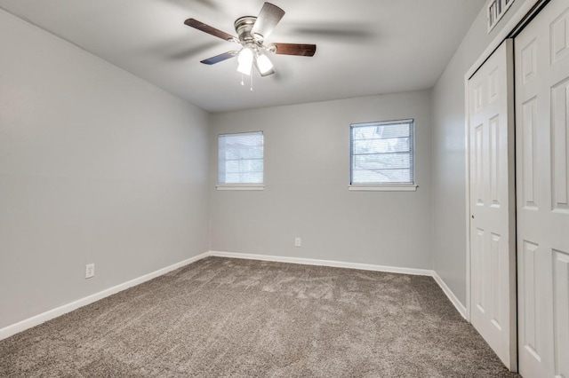 unfurnished bedroom featuring ceiling fan, carpet, and multiple windows