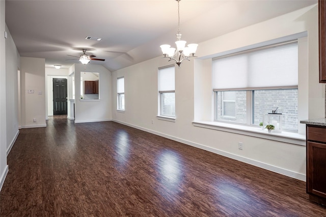 unfurnished living room featuring vaulted ceiling, a wealth of natural light, ceiling fan with notable chandelier, and dark hardwood / wood-style flooring