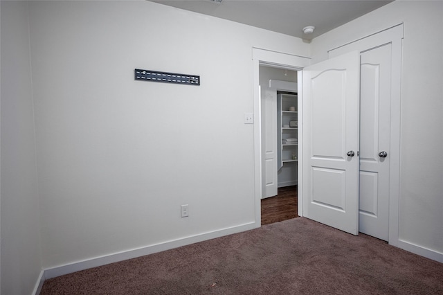 unfurnished bedroom with dark carpet