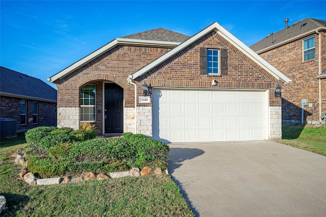 2418 San Marcos Dr, Forney, TX 75126 - view of front of home featuring central AC unit, roof with shingles, concrete driveway, an attached garage, and brick siding