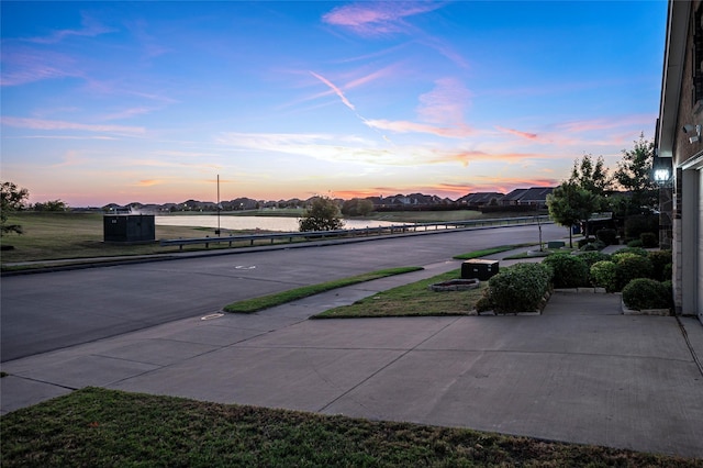 patio terrace at dusk featuring a water view