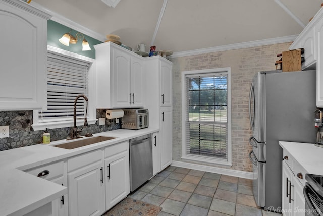 kitchen featuring backsplash, crown molding, sink, white cabinetry, and stainless steel appliances